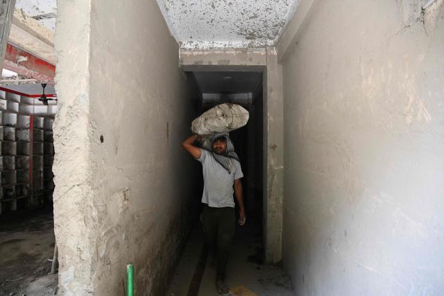 A man carries his salvaged belongings from a damaged house in the aftermath of flash floods at Trishuli in Nepal’s Nuwakot district on September 22, 2026. (Photo by PRAKASH MATHEMA / AFP)