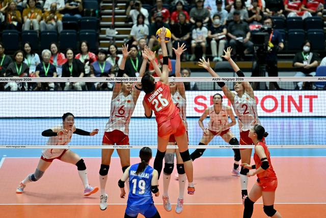 Japan's Miku Akimoto (C) spikes the ball in the women's volleyball gold medal final match between Japan and China during the 2026 Asian Games at Park Arena Komaki in Komaki, Aichi prefecture on September 22, 2026. (Photo by MOHD RASFAN / AFP)