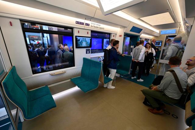People inspect the interior of a mockup at scale of Alstom's S-Bahn commuter train for the western German Rhineland region at the InnoTrans International Trade Fair for Transport Technology on September 22, 2026 in Berlin. From September 22 to 25, 2026, around 600 companies from the Railway Infrastructure and Tunnel Construction sectors will present their latest products and services, ranging from digital planning and monitoring systems to innovative construction methods and sustainable solutions for Tunnel Construction and infrastructure management. (Photo by John MACDOUGALL / AFP)