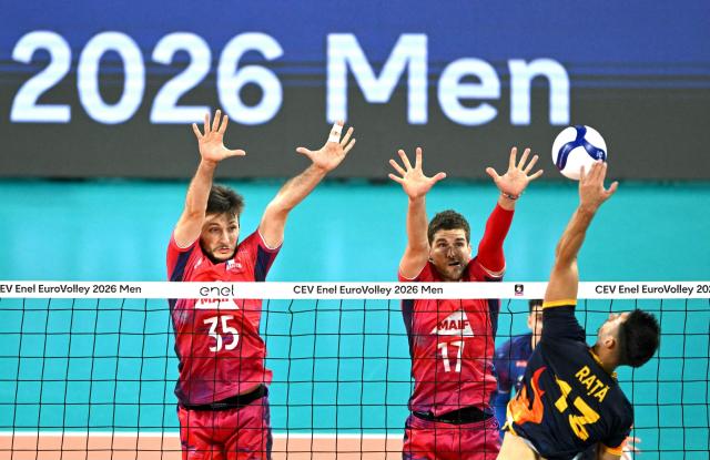 (LtoR) Romania's opposite Alexandru Rata smashes in front of France's middle blocker Simon Magnin and France's outside hitter Trevor Clevenot during the Eurovolley 2026 volleyball quarter-final match between France and Romania in Sofia on September 22, 2026. (Photo by Nikolay DOYCHINOV / AFP)
