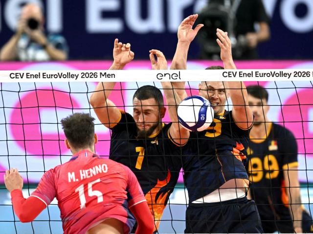 France's outside hitter Mathis Henno (L) smashes in front of Romania's middle blocker Florian Bartha (C) during the Men's EuroVolley 2026 quarter-final volleyball match between France and Romania at Arena 8888 in Sofia on September 22, 2026. (Photo by Nikolay DOYCHINOV / AFP)