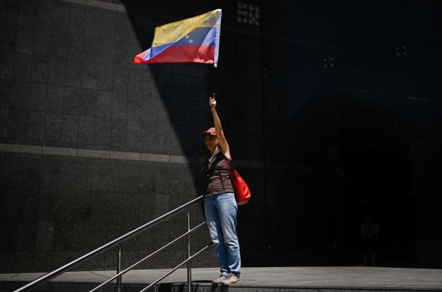 A demonstrator holds a Venezuelan flag during a protest against Venezuela's interim President Delcy Rodriguez attending the 81st United Nations General Assembly, in Caracas on September 22, 2026. (Photo by Federico PARRA / AFP)