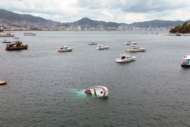 A partially submerged boat is seen in Acapulco Bay after strong waves and winds caused by Hurricane Polo in Acapulco, Guerrero state, Mexico, on September 22, 2026. Hurricane Polo strengthened to the highest category on September 22 in the Mexican Pacific, with no forecast of making landfall but with heavy rainfall expected. Polo intensified from Category 1 to Category 5 on the Saffir-Simpson scale in less than 24 hours. (Photo by Francisco RAMOS / AFP)