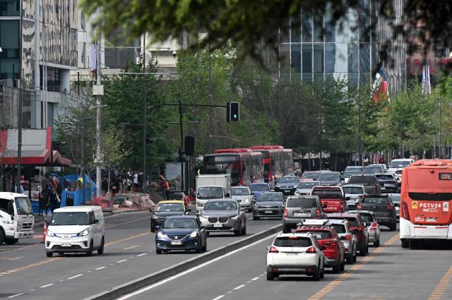 Vehicles travel along an avenue on World Car-Free Day in Santiago on September 22, 2026. (Photo by RODRIGO ARANGUA / AFP)