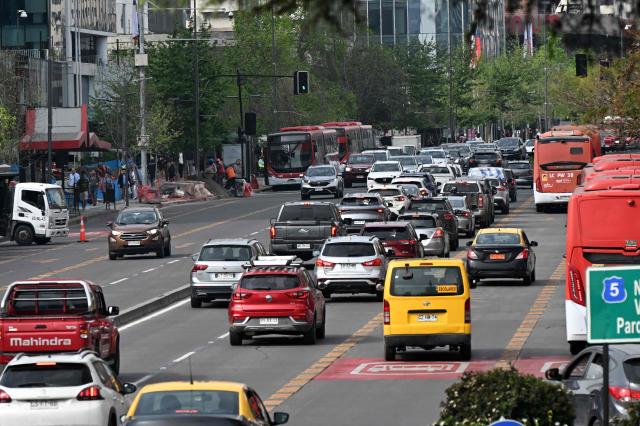Vehicles travel along an avenue on World Car-Free Day in Santiago on September 22, 2026. (Photo by RODRIGO ARANGUA / AFP)