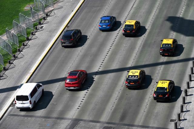 Vehicles travel along an avenue on World Car-Free Day in Santiago on September 22, 2026. (Photo by RODRIGO ARANGUA / AFP)