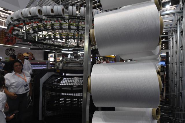 People look at textile machines during the Nextech textile trade show in Medellin, Colombia on September 22, 2026. (Photo by Jaime SALDARRIAGA / AFP)