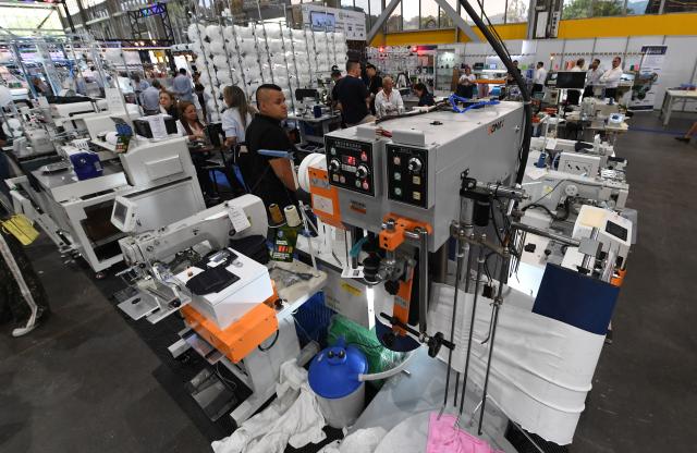 People look at textile machines during the Nextech textile trade show in Medellin, Colombia on September 22, 2026. (Photo by Jaime SALDARRIAGA / AFP)