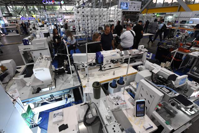 People look at textile machines during the Nextech textile trade show in Medellin, Colombia on September 22, 2026. (Photo by Jaime SALDARRIAGA / AFP)