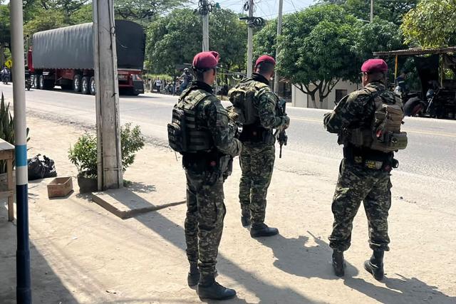 Colombian Army soldiers stand guard on a road following a military operation against the drug-related armed group Conquering Self Defense Forces of the Sierra Nevada (ACSN) in Santa Marta, Colombia on September 22, 2026. Colombia's President Abelardo de la Espriella sent troops into Santa Marta after an armed group attacked shops and burnt vehicles across the Caribbean city, he announced on September 22, 2026. The chaos followed an earlier announcement by the president that authorities had killed 13 members of the self-styled Conquering Self Defense Forces of the Sierra Nevada (ACSN), an armed group which controls cocaine trafficking routes. (Photo by Idinael FERNANDEZ / AFP)