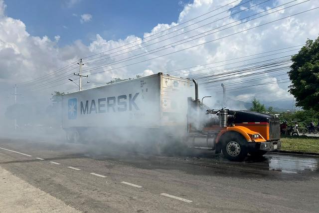 A burnt truck is seen on a road in the wake of a military operation by the Colombian Army against the drug-related armed group Conquering Self Defense Forces of the Sierra Nevada (ACSN) in Santa Marta, Colombia on September 22, 2026. Colombia's President Abelardo de la Espriella sent troops into Santa Marta after an armed group attacked shops and burnt vehicles across the Caribbean city, he announced on September 22, 2026. The chaos followed an earlier announcement by the president that authorities had killed 13 members of the self-styled Conquering Self Defense Forces of the Sierra Nevada (ACSN), an armed group which controls cocaine trafficking routes. (Photo by Idinael Fernandez / AFP)