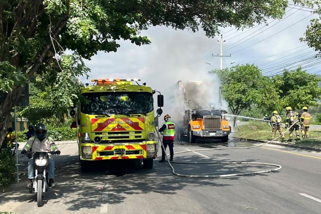 Firefighters extinguish a fire in a burnt truck in the wake of a military operation by the Colombian Army against the drug-related armed group Conquering Self Defense Forces of the Sierra Nevada (ACSN) in Santa Marta, Colombia on September 22, 2026. Colombia's President Abelardo de la Espriella sent troops into Santa Marta after an armed group attacked shops and burnt vehicles across the Caribbean city, he announced on September 22, 2026. The chaos followed an earlier announcement by the president that authorities had killed 13 members of the self-styled Conquering Self Defense Forces of the Sierra Nevada (ACSN), an armed group which controls cocaine trafficking routes. (Photo by Idinael Fernandez / AFP)
