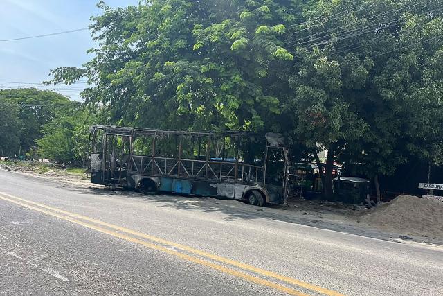 A burnt bus is seen on a road in the wake of a military operation by the Colombian Army against the drug-related armed group Conquering Self Defense Forces of the Sierra Nevada (ACSN) in Santa Marta, Colombia on September 22, 2026. Colombia's President Abelardo de la Espriella sent troops into Santa Marta after an armed group attacked shops and burnt vehicles across the Caribbean city, he announced on September 22, 2026. The chaos followed an earlier announcement by the president that authorities had killed 13 members of the self-styled Conquering Self Defense Forces of the Sierra Nevada (ACSN), an armed group which controls cocaine trafficking routes. (Photo by Idinael Fernandez / AFP)