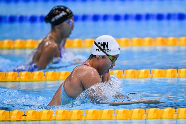 Japan's Mio Narita (L) and China's Yu Zidi compete in a heat of the women's 400m individual medley swimming event during the 2026 Asian Games at the Tokyo Aquatics Centre in Tokyo on September 23, 2026. (Photo by ANDREW CABALLERO-REYNOLDS / AFP)
