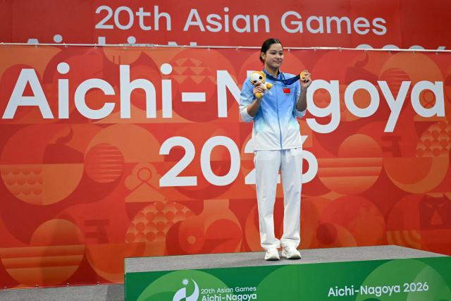 China's swimmer Yiting Yu celebrates with her gold medal on the podium during the victory ceremony of the women's 100m butterfly swimming event during the 2026 Asian Games at the Tokyo Aquatics Centre in Tokyo on September 23, 2026. (Photo by ANDREW CABALLERO-REYNOLDS / AFP)
