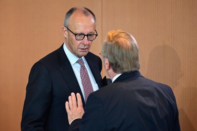 German Chancellor Friedrich Merz (L) talks with German Defence Minister Boris Pistorius as he arrives for a weekly meeting of the German cabinet at the Chancellery in Berlin, on September 23, 2026. (Photo by John MACDOUGALL / AFP)