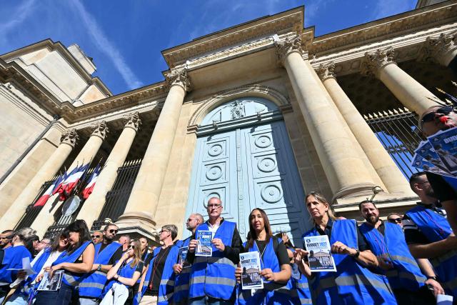 Protesters hold flyers as they take part in a demonstration by the Alliance police union in front the National Assembly, France's lower house of Parliament, in Paris on September 23, 2026. (Photo by LOU BENOIST / AFP)