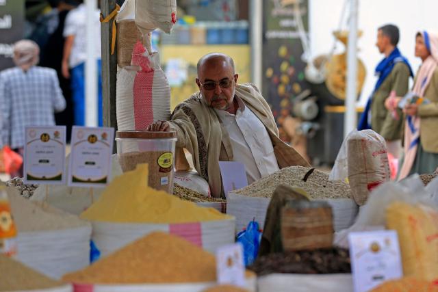 A man checks a container at a stall during an exhibition organised to promote locally grown agricultural produce, in Sanaa on September 23, 2026. (Photo by Mohammed HUWAIS / AFP)