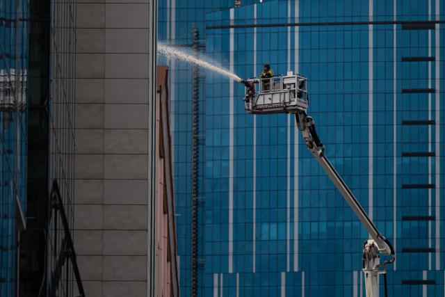 A firefighter extinguishes a fire at a building damaged following a drone strike in Kyiv on September 23, 2026, amid the Russian invasion of Ukraine. Ukraine on September 23, 2026 accused Russia of increasing its targeting of civilian transport infrastructure after renewed attacks on petrol stations, shipping and railways left at least two dead. (Photo by Genya SAVILOV / AFP)