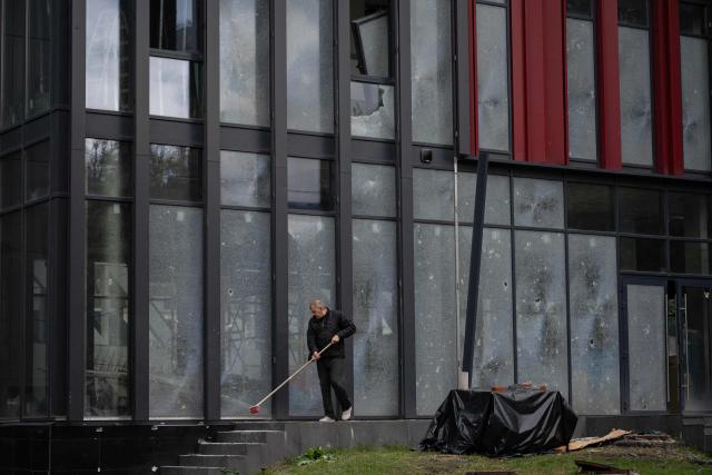 A man clears shattered glass in front of a building damaged following a drone strike in Kyiv on September 23, 2026, amid the Russian invasion of Ukraine. Ukraine on September 23, 2026 accused Russia of increasing its targeting of civilian transport infrastructure after renewed attacks on petrol stations, shipping and railways left at least two dead. (Photo by Genya SAVILOV / AFP)