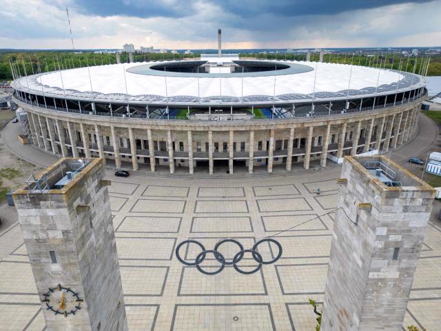 (FILES) This aerial view taken on April 15, 2024 shows the Olympic rings symbol in front of the Olympic Stadium in Berlin, Germany. According to German media reports on September 23, 2026, Berlin intends to withdraw its bid for the Olympic and Paralympic Games before the vote by the German Olympic Sports Confederation (DOSB) on Saturday, September 26. Berlin, together with Brandenburg, Saxony, and Mecklenburg-Western Pomerania, had aimed to host the Olympic Games in 2036, 2040, or 2044. (Photo by Odd ANDERSEN / AFP)