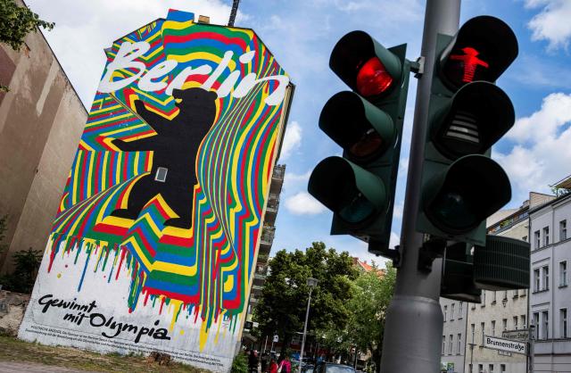 (FILES) A mural, part of the city of Berlin's campaign to host the Olympic Games in 2036, 2040, or 2044, reads: "Berlin wins with Olympia", is seen next to a traffic light in Berlin on June 15, 2026. According to German media reports on September 23, 2026, Berlin intends to withdraw its bid for the Olympic and Paralympic Games before the vote by the German Olympic Sports Confederation (DOSB) on Saturday, September 26. Berlin, together with Brandenburg, Saxony, and Mecklenburg-Western Pomerania, had aimed to host the Olympic Games in 2036, 2040, or 2044. (Photo by John MACDOUGALL / AFP)