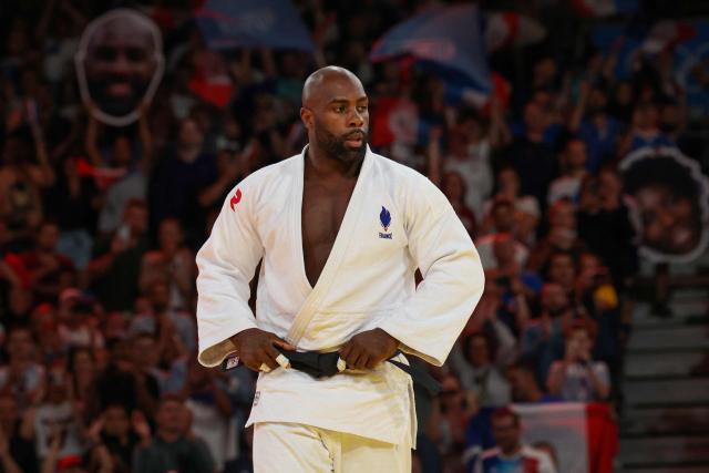 (FILES) France's Teddy Riner reacts after beating South Korea's Lee Joon-hwan (Blue) in the judo mixed team quarter-final bout between France and South Korea of the Paris 2024 Olympic Games at the Champ-de-Mars Arena, in Paris on August 3, 2024. The Paris prosecutor's office announced on Instagram on September 23, 2026, that it had opened an investigation into public racist insults and cyberbullying after noting "numerous hateful messages online" targeting Teddy Riner. (Photo by Jack GUEZ / AFP)