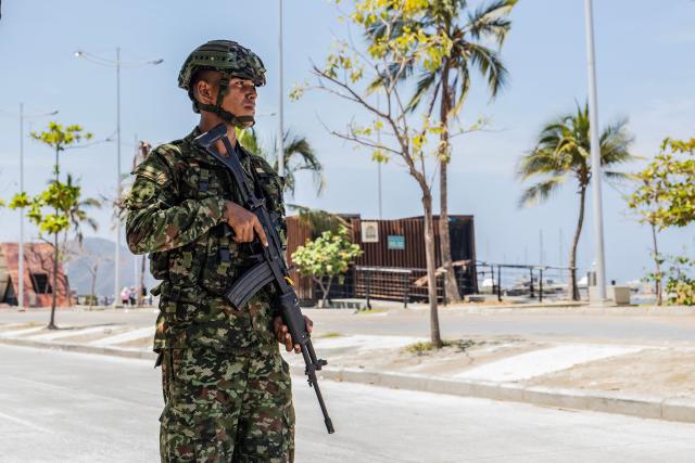 A Colombian soldier stands guard on a street following a military operation against the drug-related armed group Conquering Self Defense Forces of the Sierra Nevada (ACSN) in Santa Marta, Colombia on September 23, 2026. Colombia's President Abelardo de la Espriella sent troops into Santa Marta after an armed group attacked shops and burnt vehicles across the Caribbean city, he announced on September 22, 2026. The chaos followed an earlier announcement by the president that authorities had killed 13 members of the self-styled Conquering Self Defense Forces of the Sierra Nevada (ACSN), an armed group which controls cocaine trafficking routes. (Photo by Marco PERDOMO / AFP)