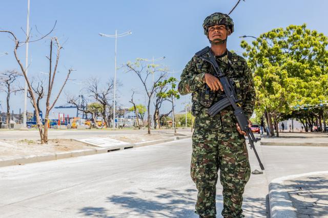 A Colombian soldier stands guard on a street following a military operation against the drug-related armed group Conquering Self Defense Forces of the Sierra Nevada (ACSN) in Santa Marta, Colombia on September 23, 2026. Colombia's President Abelardo de la Espriella sent troops into Santa Marta after an armed group attacked shops and burnt vehicles across the Caribbean city, he announced on September 22, 2026. The chaos followed an earlier announcement by the president that authorities had killed 13 members of the self-styled Conquering Self Defense Forces of the Sierra Nevada (ACSN), an armed group which controls cocaine trafficking routes. (Photo by Marco PERDOMO / AFP)