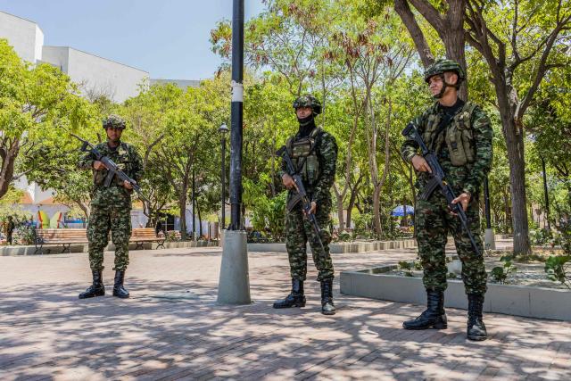 Colombian soldiers stand guard on a street following a military operation against the drug-related armed group Conquering Self Defense Forces of the Sierra Nevada (ACSN) in Santa Marta, Colombia on September 23, 2026. Colombia's President Abelardo de la Espriella sent troops into Santa Marta after an armed group attacked shops and burnt vehicles across the Caribbean city, he announced on September 22, 2026. The chaos followed an earlier announcement by the president that authorities had killed 13 members of the self-styled Conquering Self Defense Forces of the Sierra Nevada (ACSN), an armed group which controls cocaine trafficking routes. (Photo by Marco PERDOMO / AFP)