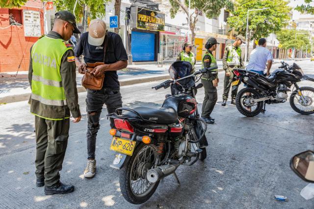 Police officers work on a check point on a street following a military operation against the drug-related armed group Conquering Self Defense Forces of the Sierra Nevada (ACSN) in Santa Marta, Colombia on September 23, 2026. Colombia's President Abelardo de la Espriella sent troops into Santa Marta after an armed group attacked shops and burnt vehicles across the Caribbean city, he announced on September 22, 2026. The chaos followed an earlier announcement by the president that authorities had killed 13 members of the self-styled Conquering Self Defense Forces of the Sierra Nevada (ACSN), an armed group which controls cocaine trafficking routes. (Photo by Marco PERDOMO / AFP)