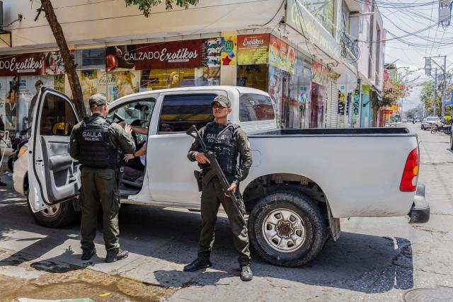 Police officers work on a check point on a street following a military operation against the drug-related armed group Conquering Self Defense Forces of the Sierra Nevada (ACSN) in Santa Marta, Colombia on September 23, 2026. Colombia's President Abelardo de la Espriella sent troops into Santa Marta after an armed group attacked shops and burnt vehicles across the Caribbean city, he announced on September 22, 2026. The chaos followed an earlier announcement by the president that authorities had killed 13 members of the self-styled Conquering Self Defense Forces of the Sierra Nevada (ACSN), an armed group which controls cocaine trafficking routes. (Photo by Marco PERDOMO / AFP)