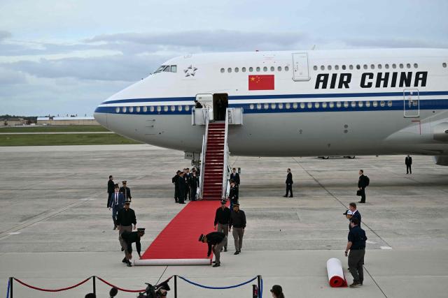 US military personnel unroll the red carpet at the bottom of the stairs of an Air China plane carrying Chinese President Xi Jinping at Joint Base Andrews in Maryland on September 23, 2026. Xi is visiting the United States from September 23 to 25. (Photo by Kent NISHIMURA / AFP)