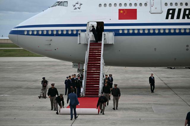 US military personnel unroll the red carpet at the bottom of the stairs of an Air China plane carrying Chinese President Xi Jinping at Joint Base Andrews in Maryland on September 23, 2026. Xi is visiting the United States from September 23 to 25. (Photo by Kent NISHIMURA / AFP)