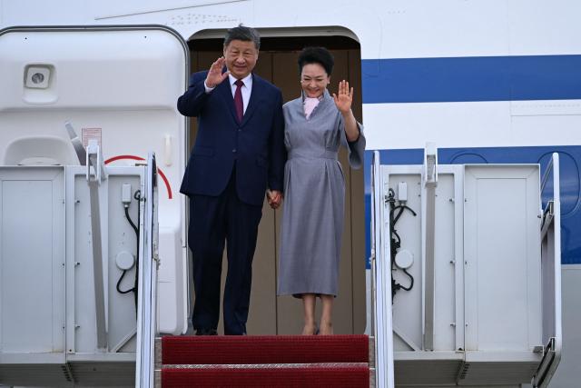 Chinese President Xi Jinping and his wife Peng Liyuan wave as they step off their plane upon arrival at Joint Base Andrews in Maryland on September 23, 2026. Xi is visiting the United States from September 23 to 25. (Photo by Brendan SMIALOWSKI / AFP)