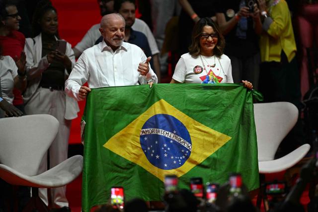 Brazil's President and presidential candidate Luiz Inacio Lula da Silva (L) and Brazil's First Lady Rosangela da Silva hold a Brazilian flag during a campaign rally with artists and intellectuals at the Fundicao Progresso cultural center in the Lapa neighborhood of central Rio de Janeiro, Brazil, on September 23, 2026. Brazil will hold a presidential election on October 4, 2026. (Photo by MAURO PIMENTEL / AFP)