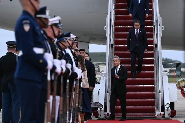 Chinese Foreign Minister Wang Yi and other officials step off the plane carrying Chinese President Xi Jinping upon arrival at Joint Base Andrews in Maryland on September 23, 2026. Xi is visiting the United States from September 23 to 25. (Photo by Brendan SMIALOWSKI / AFP)