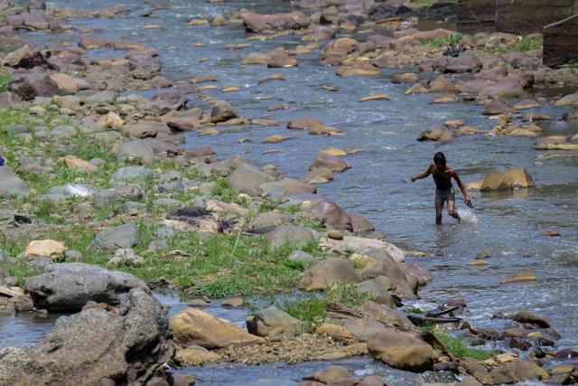 A man cools off in the Cali River amid high temperatures linked to the El Nino weather phenomenon in Cali, Colombia, on September 23, 2026. (Photo by JOAQUIN SARMIENTO / AFP)