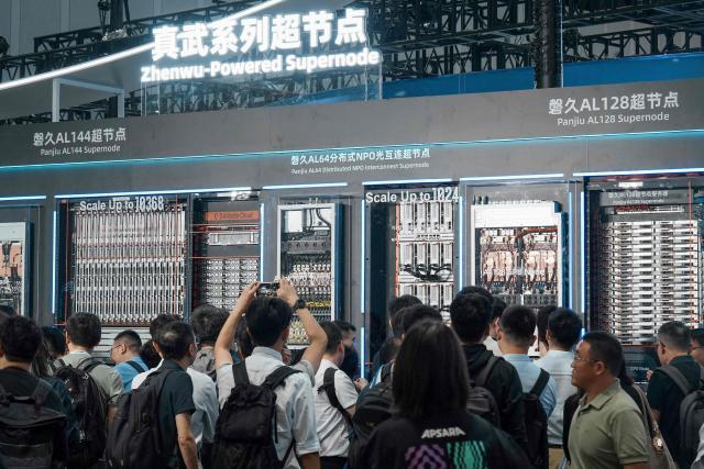 People examine the Panjiu AL144 Supernode server (L), a high-performance AI server developed by Alibaba Cloud, at the 5th Global Digital Trade Fair in Hangzhou, eastern China's Zhejiang province on September 22, 2026. (Photo by CN-STR / AFP) / China OUT