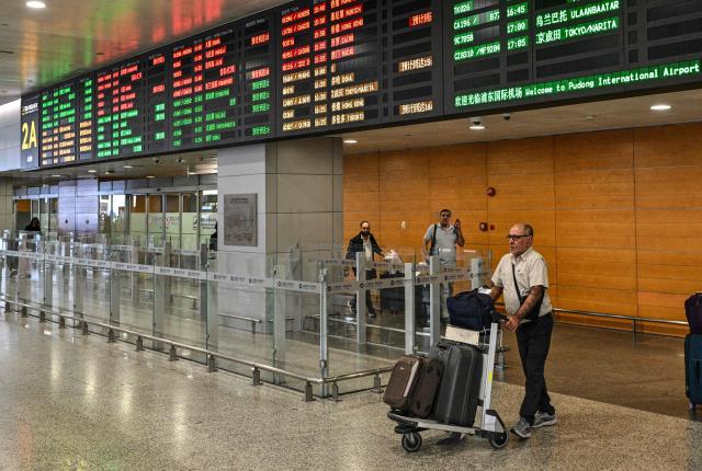 A man arriving from Tehran walks at Shanghai Pudong International Airport in Shanghai on September 24, 2026. Iranian airlines were forced to cancel some international flights after the United States tightened sanctions on Iran's aviation industry. China said that it opposed the US sanctions, calling them illegal. (Photo by Hector RETAMAL / AFP)
