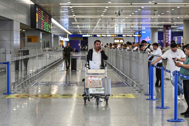 A man arriving from Tehran walks at Shanghai Pudong International Airport in Shanghai on September 24, 2026. Iranian airlines were forced to cancel some international flights after the United States tightened sanctions on Iran's aviation industry. China said that it opposed the US sanctions, calling them illegal. (Photo by Hector RETAMAL / AFP)