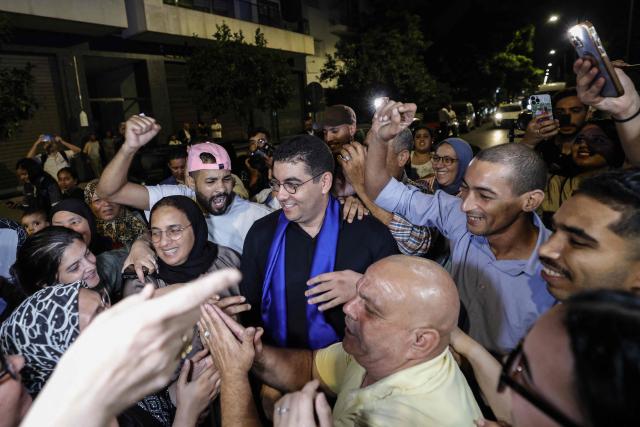 Morocco's Minister of Youth, Culture and Communication and member of the Authenticity and Modernity Party (PAM), Mohamed Mehdi Bensaid (C), celebrates with party members after the announcement of the provisional results of the legislative elections in the early hours of September 24, 2026. Morocco's centre-right Authenticity and Modernity Party (PAM), which is part of the kingdom's ruling coalition, came out ahead in September 23's parliamentary election after winning 97 out of 395 seats, according to provisional results. (Photo by Abdel Majid BZIOUAT / AFP)