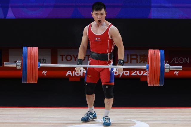 North Korea's Pang Un Chol celebrates as he competes in the men's 60kg weightlifting final at the 2026 Asian Games in Nagoya on September 24, 2026. (Photo by DAVID GRAY / AFP)