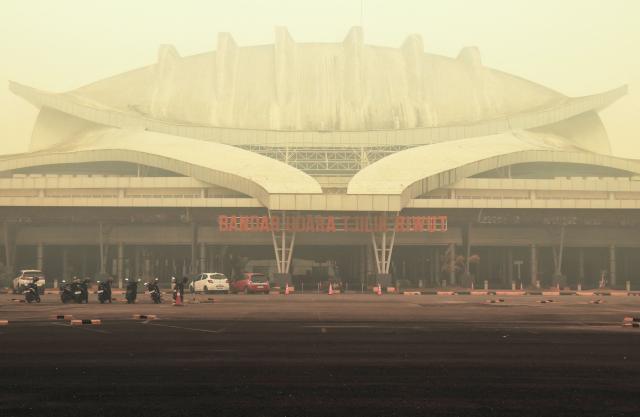 The facade of Tjilik Riwut Airport is enveloped in haze in Palangkaraya, Central Kalimantan, on September 24, 2026. Low visibility caused by persistent forest fires has hampered both commercial air travel and aerial firefighting operations across the province. (Photo by REINA / AFP)