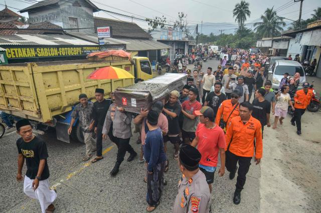 Mourners and local emergency personnel carry the casket of Surakman, a crew member of the Arupadhatu 1 speedboat, during his funeral procession to Ki Demang public cemetery at Sukajadi village, Pandeglang, Banten province, on September 24, 2026. Surakman went missing on September 7 while transporting journalists covering the eruption of Mount Anak Krakatau. (Photo by RONALD SIAGIAN / AFP)