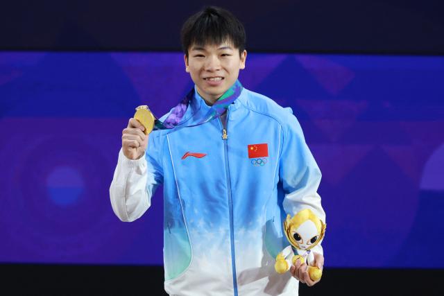 China's Yang Yang celebrates with his gold medal after winning the men's 60kg weightlifting final at the 2026 Asian Games in Nagoya on September 24, 2026. (Photo by DAVID GRAY / AFP)
