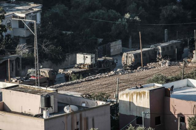 Israeli army vehicles are gathered along a road during an operation to demolish the home of Palestinian prisoner Dawas Hassoun in the Palestinian village of Beit Imrin, in the Israeli-occupied West Bank, on September 24, 2026. Hassoun is accused by Israeli authorities of carrying out a car-ramming attack in March 2026 that killed an Israeli settler. (Photo by Mohammad MANSOUR / AFP)
