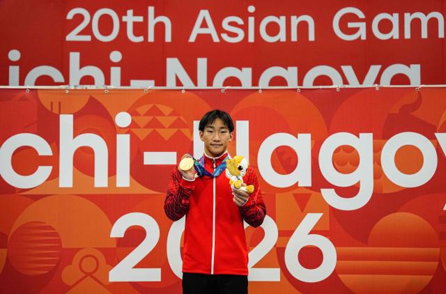 Gold medallist and world record holder Japan's Shin Ohashi celebrates on the podium during the victory ceremony of the men's 200m breaststroke swimming event during the 2026 Asian Games at the Tokyo Aquatics Centre in Tokyo on September 24, 2026. (Photo by Yuichi YAMAZAKI / AFP)
