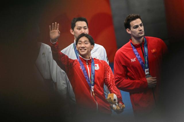 Gold medallist and world record holder Japan's Shin Ohashi (C) celebrates following the victory ceremony of the men's 200m breaststroke swimming event during the 2026 Asian Games at the Tokyo Aquatics Centre in Tokyo on September 24, 2026. (Photo by ANDREW CABALLERO-REYNOLDS / AFP)