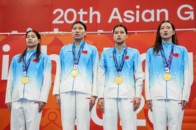 Gold medallists China's Li Jiaping, Liu Yaxin, Yu Yiting and Li Bingjie pose on the podium during the victory ceremony of the women's 4 x 200m freestyle relay swimming event during the 2026 Asian Games at the Tokyo Aquatics Centre in Tokyo on September 24, 2026. (Photo by Yuichi YAMAZAKI / AFP)